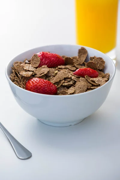 View of bowl of cereals and orange juice