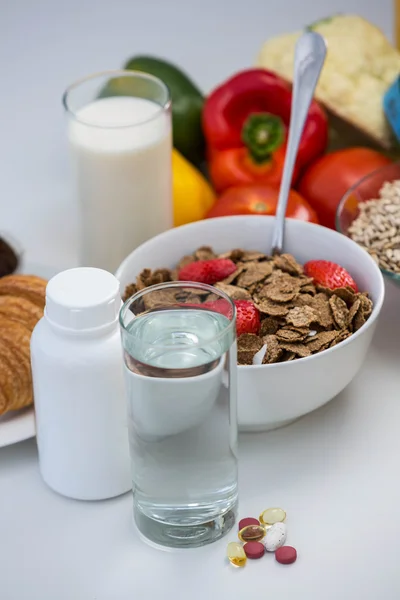View of bowl of cereals, pills and food