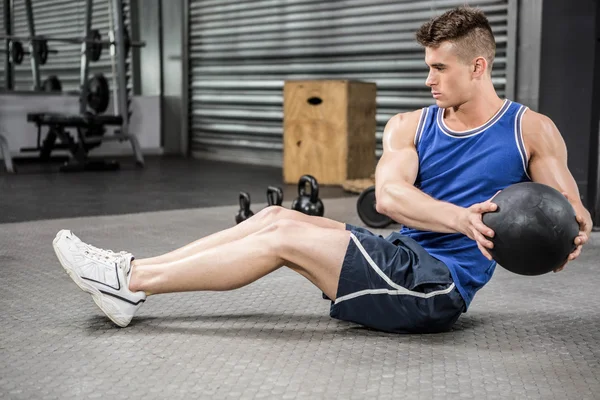 Muscular man training with medicine ball