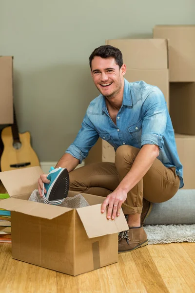 Young man unpacking carton boxes