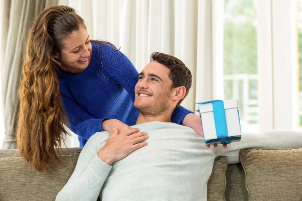 Woman giving a surprise gift to her man