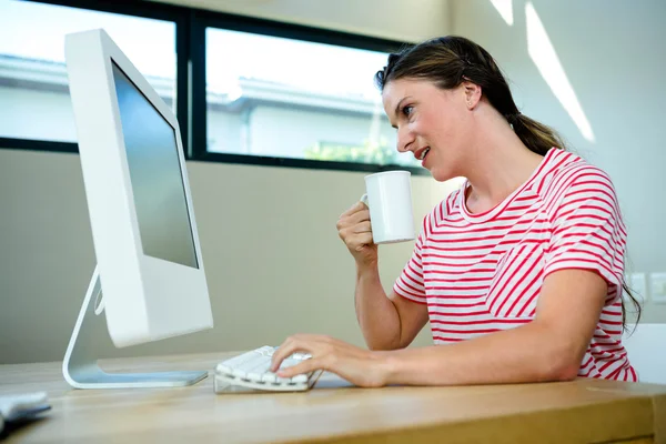 Woman sipping coffee at her desk