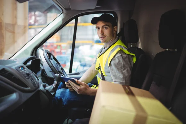 Delivery driver using tablet in van