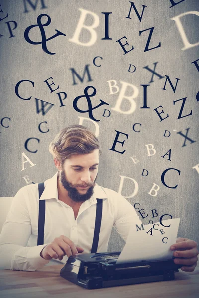 Hipster using typewriter at desk in office