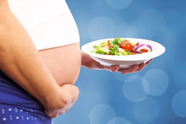 Pregnant woman eating a salad