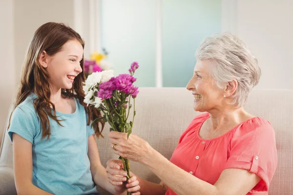 Grandmother giving flowers to granddaughter