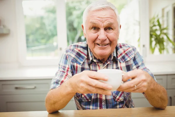 Man sitting at table with cup of coffee