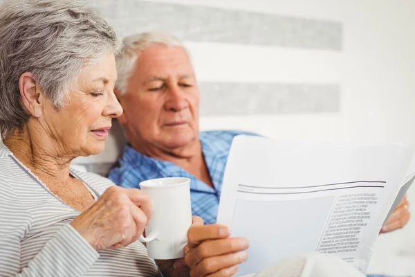 Senior couple reading newspaper