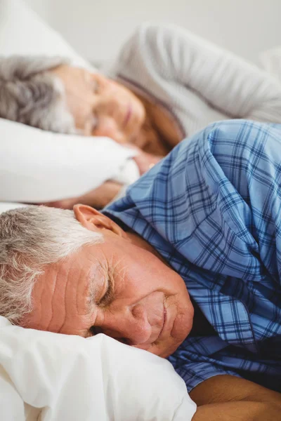 Senior couple sleeping on bed
