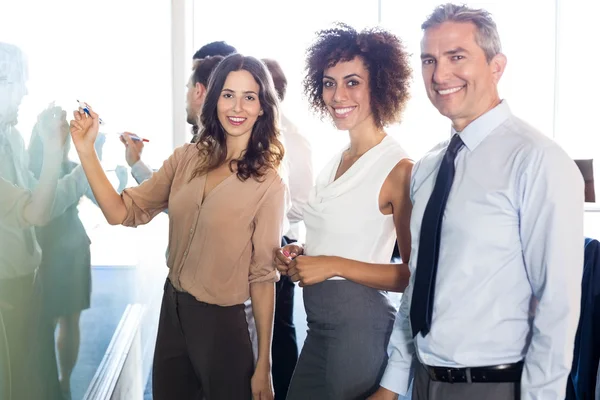 Business people writing on white board