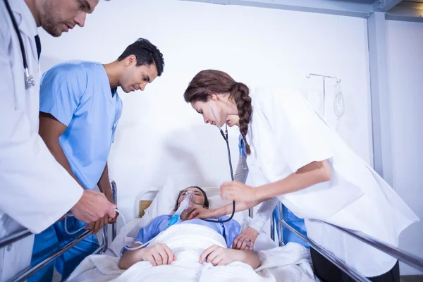 Doctors examining patient on bed