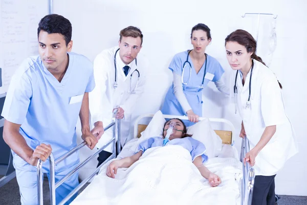 Doctors standing near patient on bed