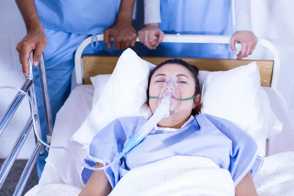 Patient with oxygen mask on bed