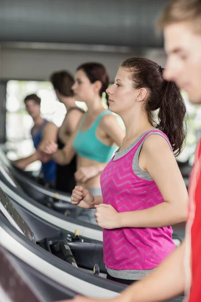 Smiling muscular woman on treadmill