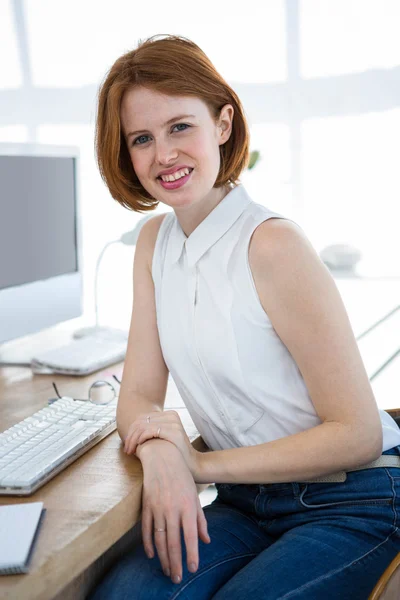 Smiling hipsterbusiness woman at desk