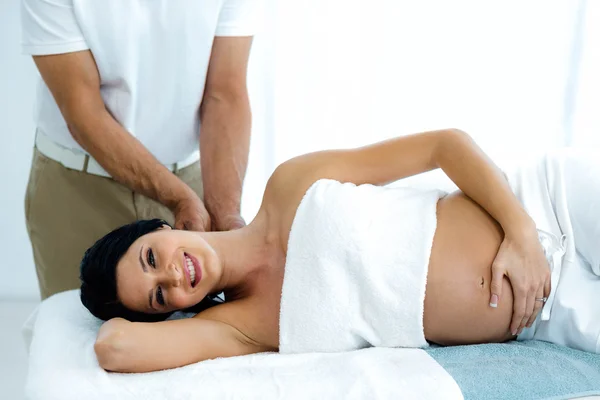 Pregnant woman receiving a back massage