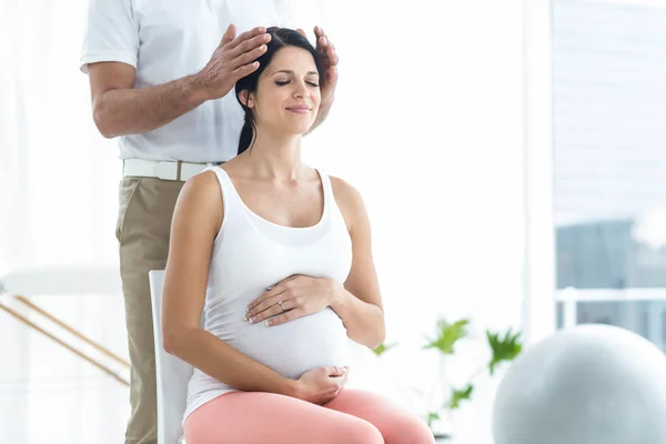 Pregnant woman receiving a head massage