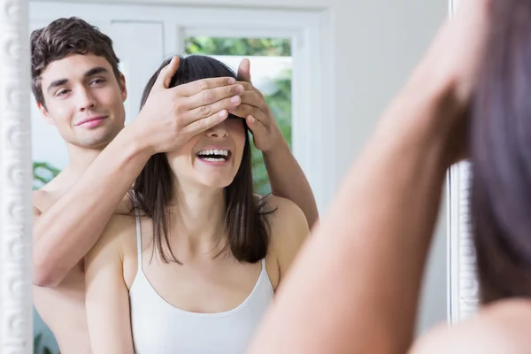 Man covering woman's eyes