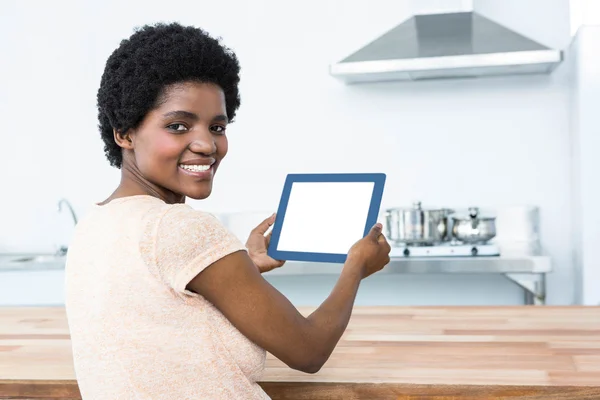 Pregnant woman using digital tablet in kitchen