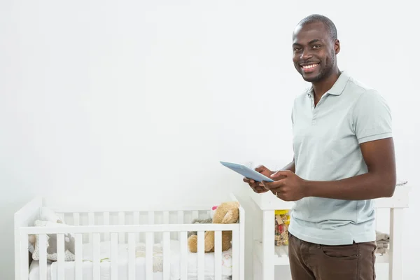 Smiling man standing next to a cradle