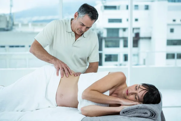 Pregnant woman receiving a back massage