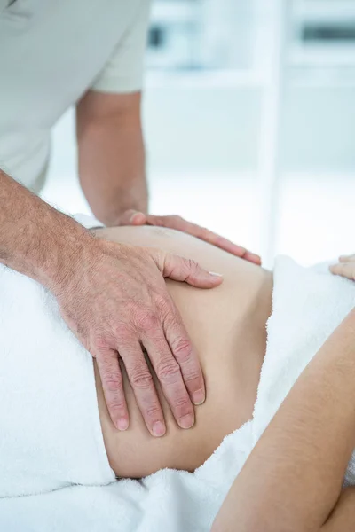 Pregnant woman receiving a stomach massage