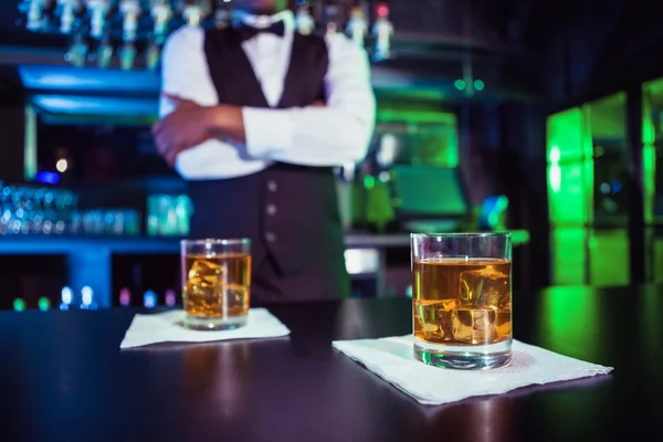 Two glasses of whiskey on bar counter