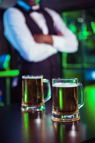 Two glasses of beer on bar counter