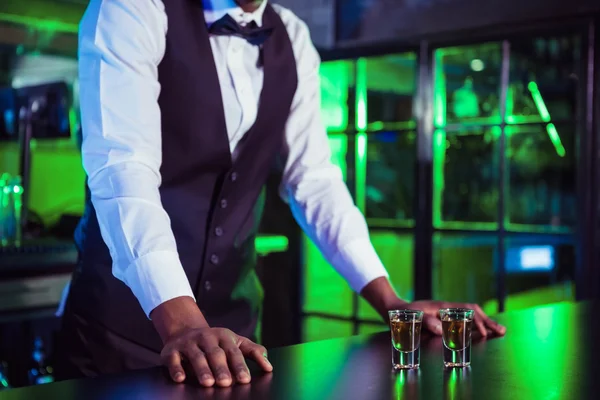 Two glasses of tequila on bar counter