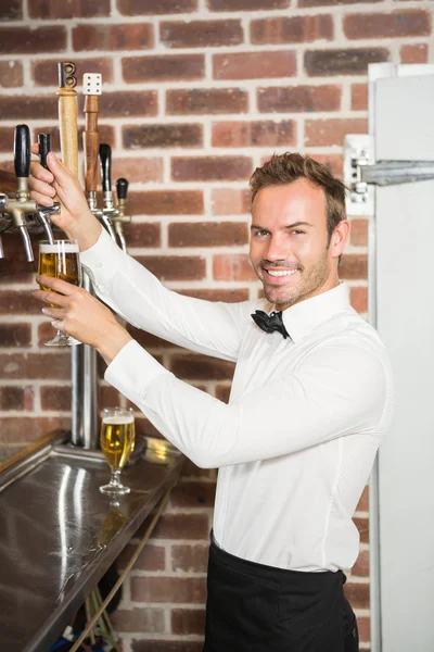 Handsome bar tender pouring a pint