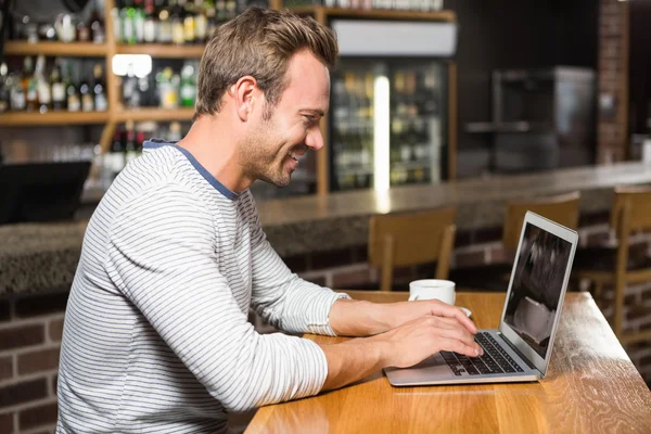 Man using laptop and having coffee