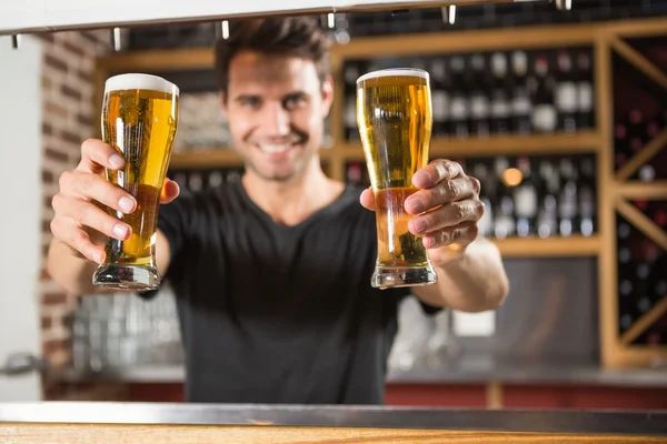 Handsome barman holding a pint of beer