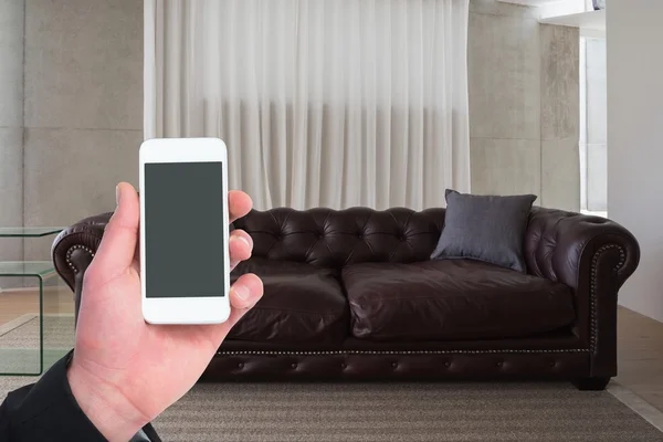 Man holding smartphone in living room