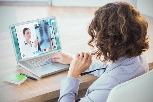 Businesswoman using laptop at desk