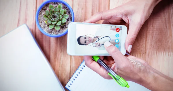 Hands holding smartphone and taking notes