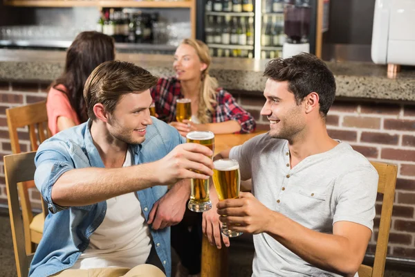 Men toasting in front while women talking