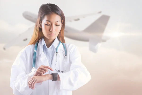 Asian doctor using her smart watch
