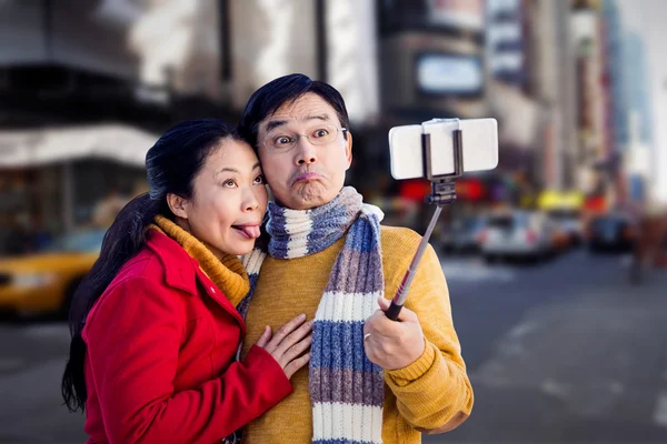 Asian couple on balcony taking selfie