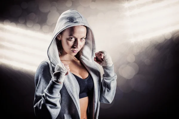 Female boxer in hood with fighting stance