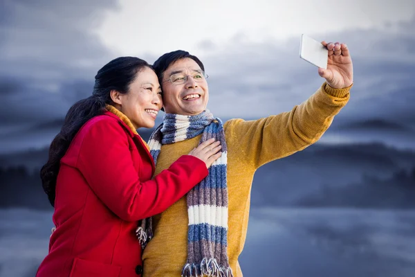 Asian couple on balcony taking selfie