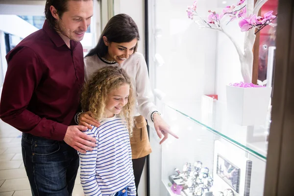 Happy family window shopping in mall