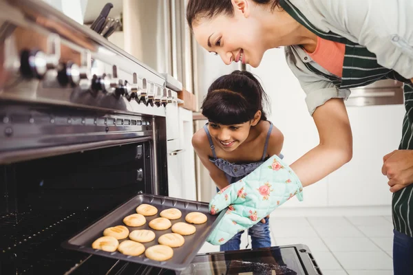 Mother and daughter placing cookies