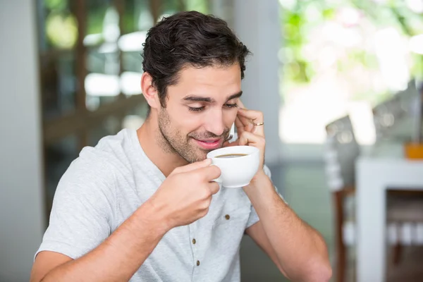 Man having coffee and talking on phone