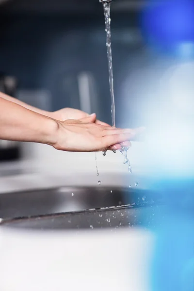 Woman cleaning hands in kitchen