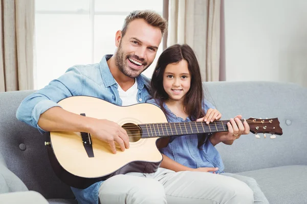 Father playing guitar with daughter