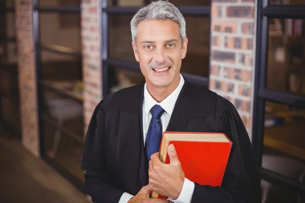 Lawyer standing with red book at office
