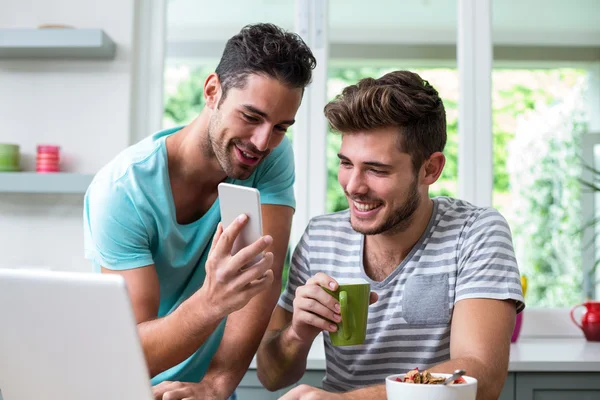 Man showing phone to friend