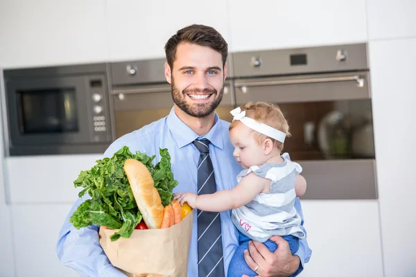 Businessman carrying vegetables and daughter