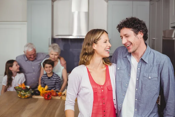 Family laughing in kitchen