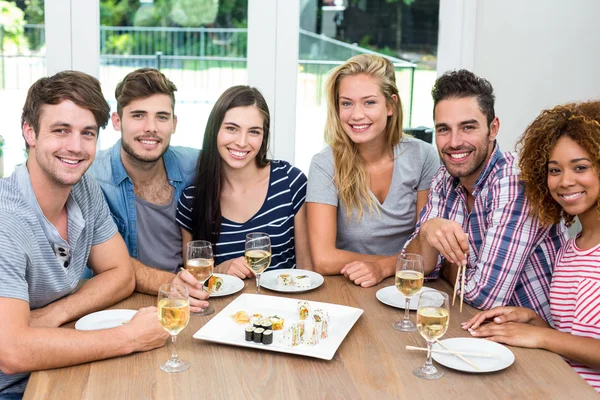 Friends enjoying wine and sushi